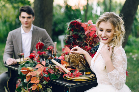 The bride with the owl on blurred groom background. Autumn weddingの写真素材