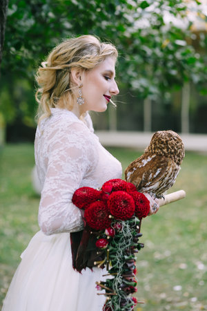 The owl sits on the girls hand. The bride with the owl.の写真素材
