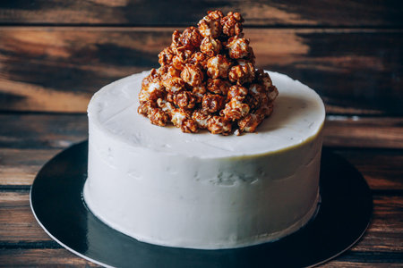 Cheesecake with caramel popcorn on the wooden background top view. Artwork.の写真素材