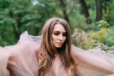 Portrait of beautiful caucasian girl with closed eyes in green leaves. Soft focus. Fashionの写真素材