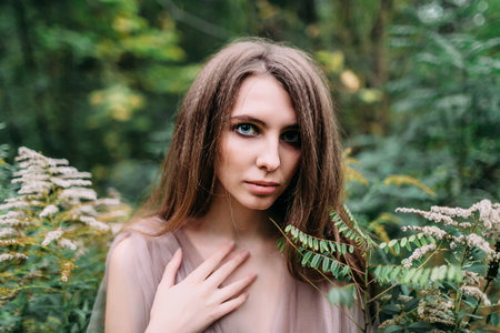Portrait of beautiful caucasian girl in green leaves. Soft focusの写真素材