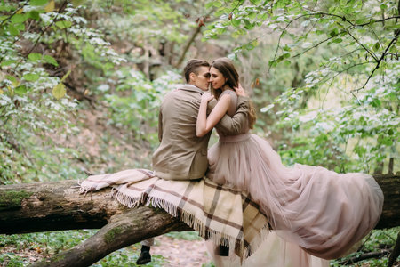 Romantic couple is gently hugs on the log. Autumn weddingの写真素材