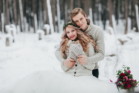 Newlyweds are hugging in the winter forest. Couple in love. Winter wedding ceremony.の写真素材