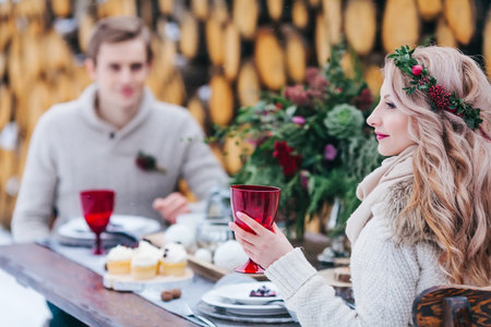 Elegant lady hold a red wineglass on blurred boyfrineds background. Selective focus on the girl.の写真素材