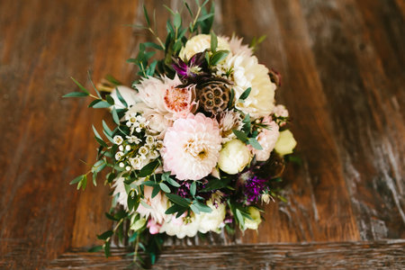 Rustic wedding bouquet with white dahlias, peonies, and greens on a wooden floor. Artworkの写真素材
