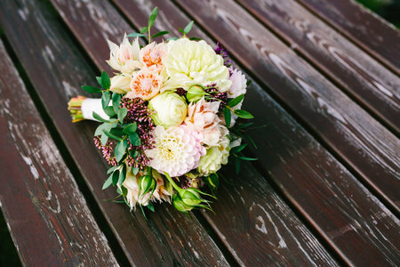 Bridal bouquet lie on the brown wooden table. Artwork. Top viewの写真素材