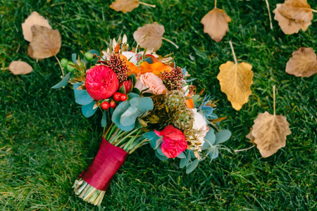 Wedding bouquet of red and cream roses on green grass. Top view. Artwork. Close-upの写真素材