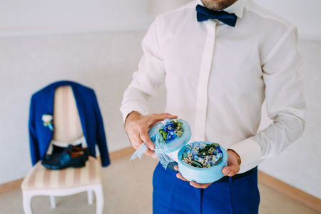 Groom holds a round box with Wedding rings with blue flowers. Artwork. Soft focusの写真素材