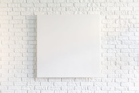 Canvas poster in vintage loft interior, background with pace for text, template design. Empty picture on white old brick wall. Mock up template for adding your content.の写真素材