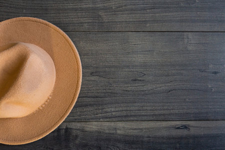 brown hat on dark wooden background with place for text. elegant accessories. Minimalistic concept of home decor. Template.の写真素材