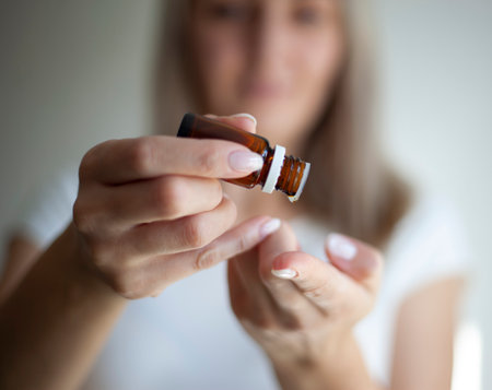 Aromatherapy, cute asian young woman hand hold bottle of essential perfume and drop oil, enjoying smell fragrance of herbal from medicine natural organic at home. Therapy treatment, beauty skin careの写真素材