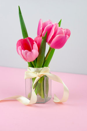 Bouquet of pink tulips in a vase isolated on a light background.の写真素材