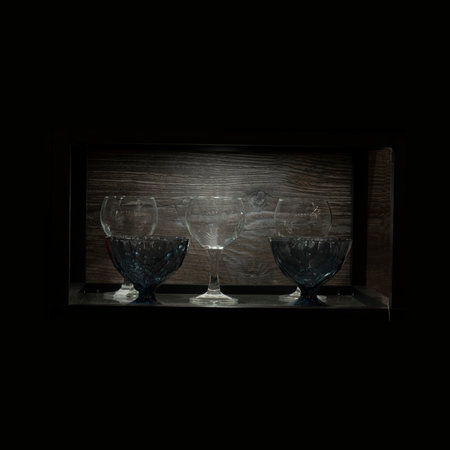 Beautiful wine glasses stand on a shelf in a mall cabinetの写真素材