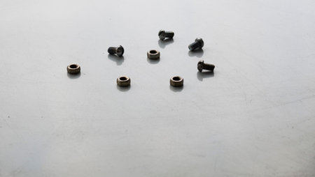 A set of bolts and nuts lie on the table