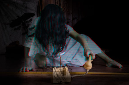 Halloween concept. a scary girl wearing a white nightie. witch. with the phone in hand