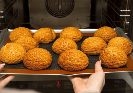 fresh ruddy buns just from the oven. appetizing. buns on the baking sheet. kitchen. bakeryの写真素材