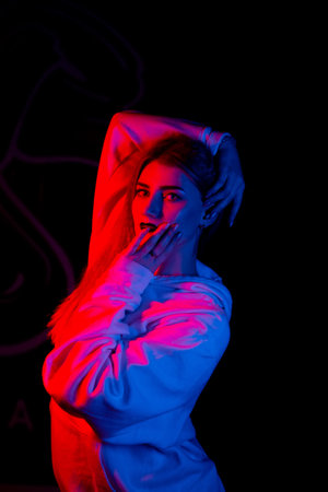Fashion portrait of young elegant woman. Colored background, studio shot .beautiful neon lightの写真素材