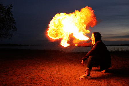 young girl by the sea shows a show with fire. details for working with fire. work with fire in nature.の写真素材