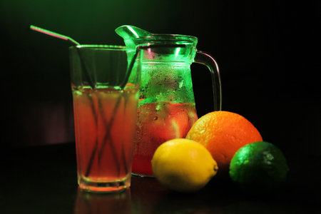 summer refreshing, lemonade drink. mix of fruits. lemon, lime, orange, mint. decanter and glass close up. there are fruits nearbyの写真素材