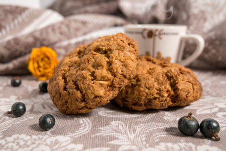 Homemade oatmeal cookies and a cup of coffee on a silver cloth.の写真素材