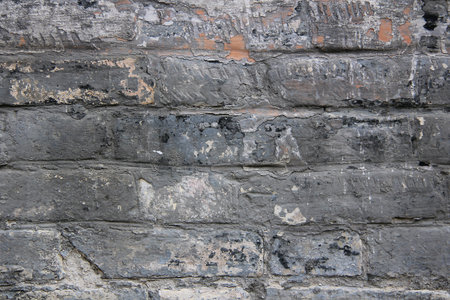 Close-up of old dirty brick wall with devastating bricks textured background.の写真素材