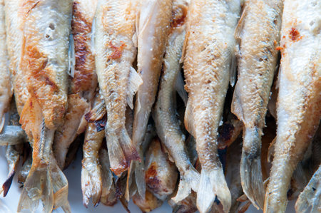 Fried small smelt fish on white plateの写真素材