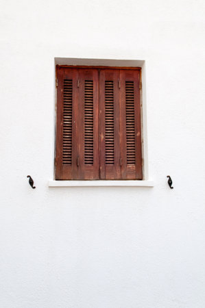 Window with closed shutters on a white wall, Crete Island, Greeceの写真素材