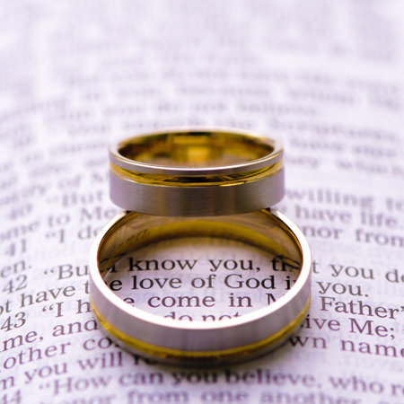Wedding rings on a Bible with Love of God messageの写真素材