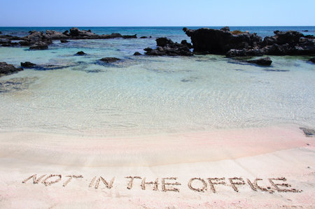 OUT OF OFFICE written on sand on a beautiful beacOUT OF OFFICE written on sand on a beautiful beach, blue waves in background, blue waves in background .Relax concept imageの写真素材