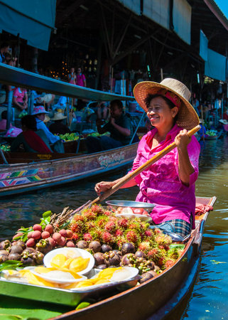 Ratchaburi, Thailand - May 24, 2014: Thai locals sell food and souvenirs at famous Damnoen Saduak floating market on  May 24, 2014 in Thailand, in the old traditional way of selling from small boats.のeditorial素材