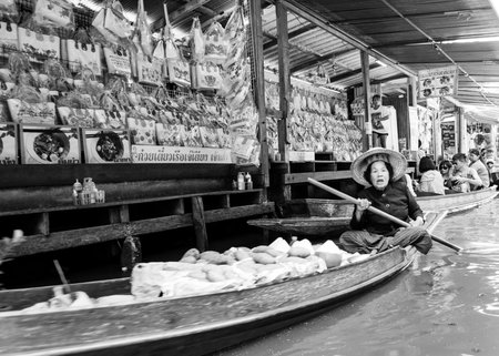 Ratchaburi, Thailand - May 24, 2014: Thai locals sell food and souvenirs at famous Damnoen Saduak floating market on  May 24, 2014 in Thailand, in the old traditional way of selling from small boats.のeditorial素材