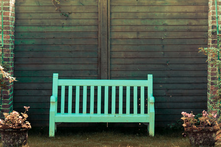 White Wooden garden bench in English garden, retro color filter appliedの写真素材