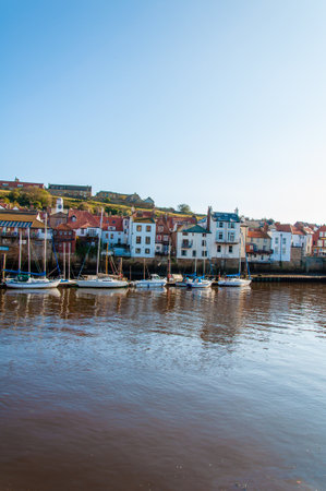 Whitby, North Yorkshire, UK - October 12, 2014: Scenic view of Whitby city and abbey in sunny autumn day.Whitby is a seaside town and port in North Yorkshire, UK. Its attraction as a tourist destination is enhanced by its association with the world famousのeditorial素材