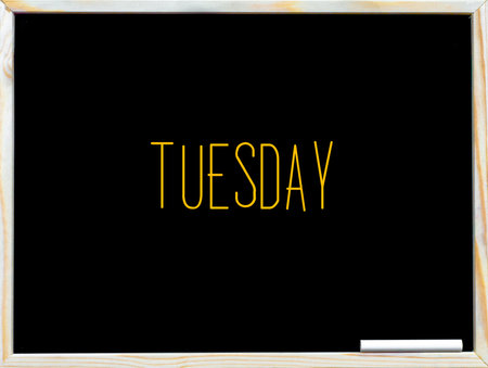 Tuesday, vintage chalk text on blackboard, white piece of chalk in the corner, Time passing conceptual imageの写真素材