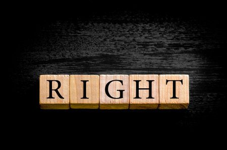 Word RIGHT. Wooden small cubes with letters isolated on black background with copy space available. Concept image.の写真素材