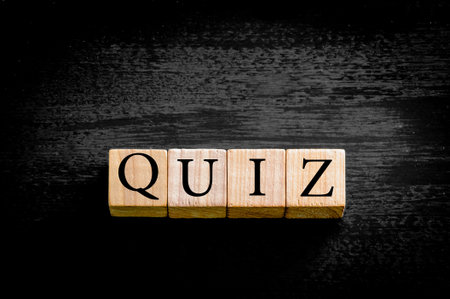 Word QUIZ. Wooden small cubes with letters isolated on black background with copy space available. Concept image.の写真素材