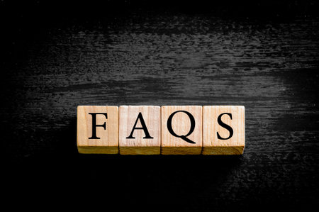 Word FAQS. Wooden small cubes with letters isolated on black background with copy space available. Concept image.の写真素材