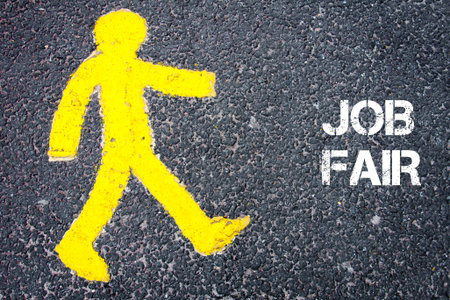 Yellow pedestrian figure on the road walking towards JOB FAIR. Conceptual image with Text message over asphalt background.の写真素材