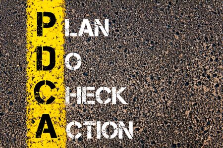 Concept image of Business Acronym PDCA as PLAN DO CHECK ACTION written over road marking yellow paint line.の写真素材