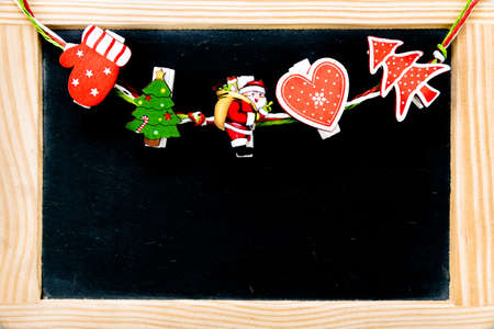 Christmas decorations on pegs over Vintage Chalkboard with wooden frame, copy space availableの写真素材