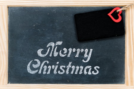 Wooden frame vintage chalkboard with Merry Christmas message, tag and red heart shape, copy space available, love and holidays conceptの写真素材