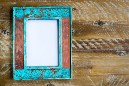Vintage photo frame over wood background with empty white canvas, copy space available