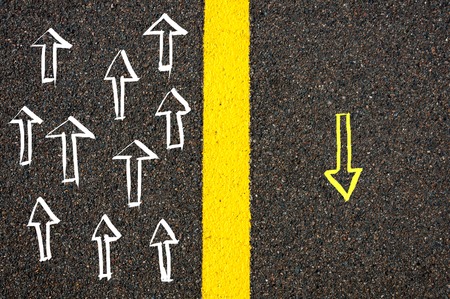 Road marking yellow paint dividing line between arrows going in different directions, Find Your Own Way conceptの写真素材