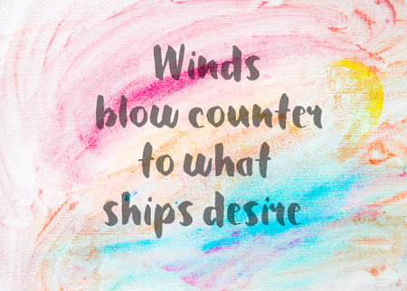 Winds blow counter to what ships desire. Inspirational quote over abstract water color textured...