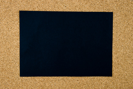 Blank black paper note over cork board background, copy space availableの写真素材