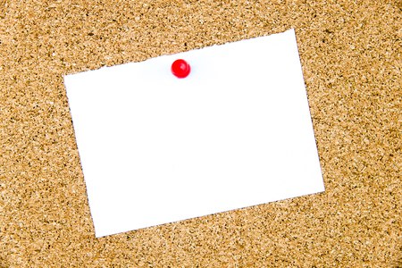 Blank white paper note pinned on cork board with red thumbtack, copy space availableの写真素材