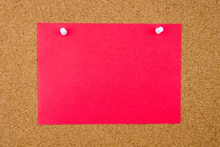 Blank orange paper note pinned on cork board with white thumbtacks, copy space availableの写真素材