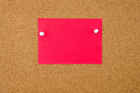 Blank red paper note pinned on cork board with white thumbtacks, copy space available