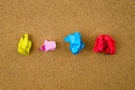 Colorful crumpled papers over cork backgroundの写真素材