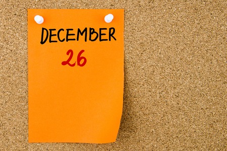 26 DECEMBER written on orange paper note pinned on cork board with white thumbtacks, copy space availableの写真素材